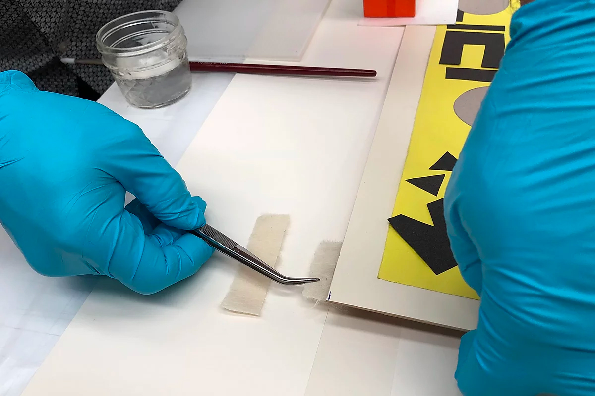 Lowy custom frame fitter mounting a work on paper with archival materials