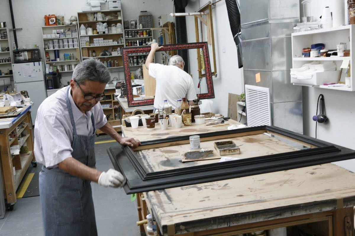 A Lowy framer maker staining a reproduction frame